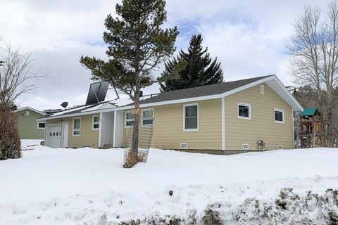Single-story house with new tan lap siding and white trim beside deep snow